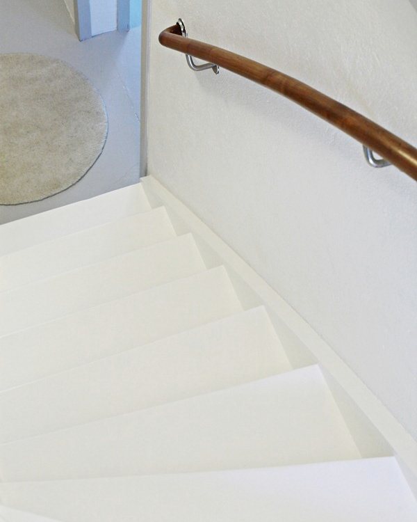 Looking down the finished white staircase from the top, all white from this direction