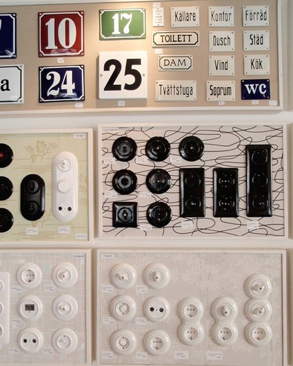 Enamel house numbers and room signs above trays of period light switches