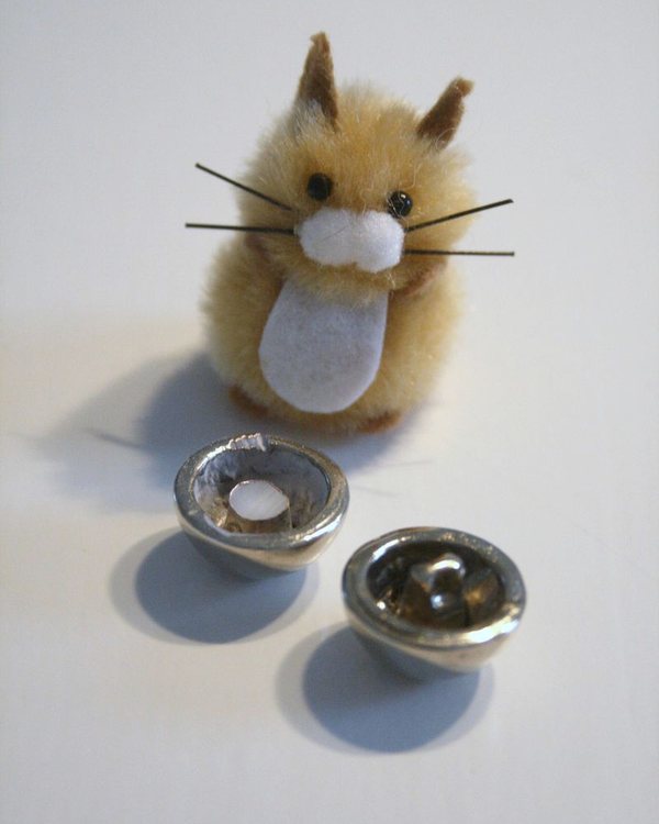 A small fluffy chick figure beside two concave buttons used as bases