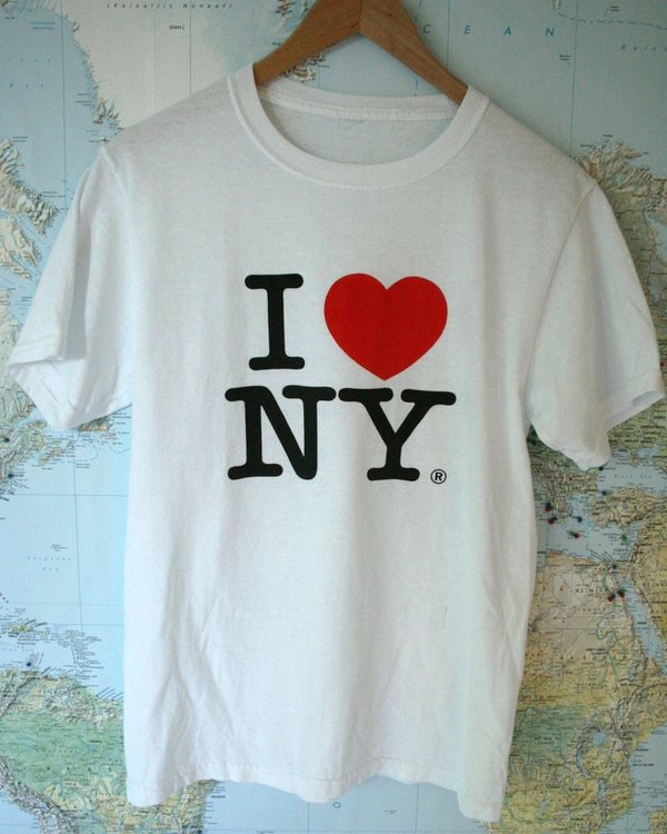 The souvenir T-shirt on a hanger against a map background