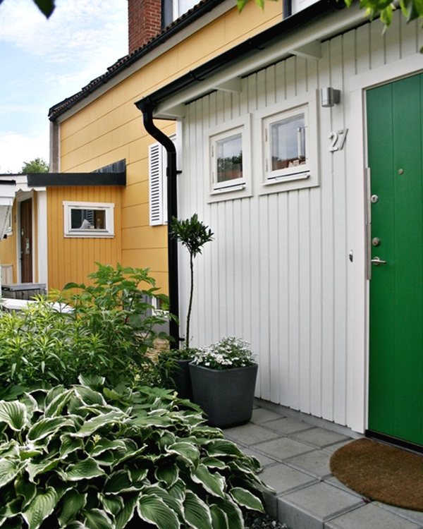 The front of the house with the green door, the trellis screening the side