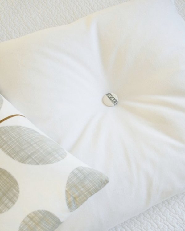 The finished button cushion, a covered button pulling the centre of the cover in