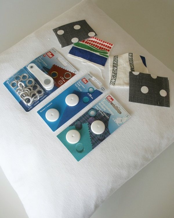Packets of grommets and covered-button kits laid on the pillow