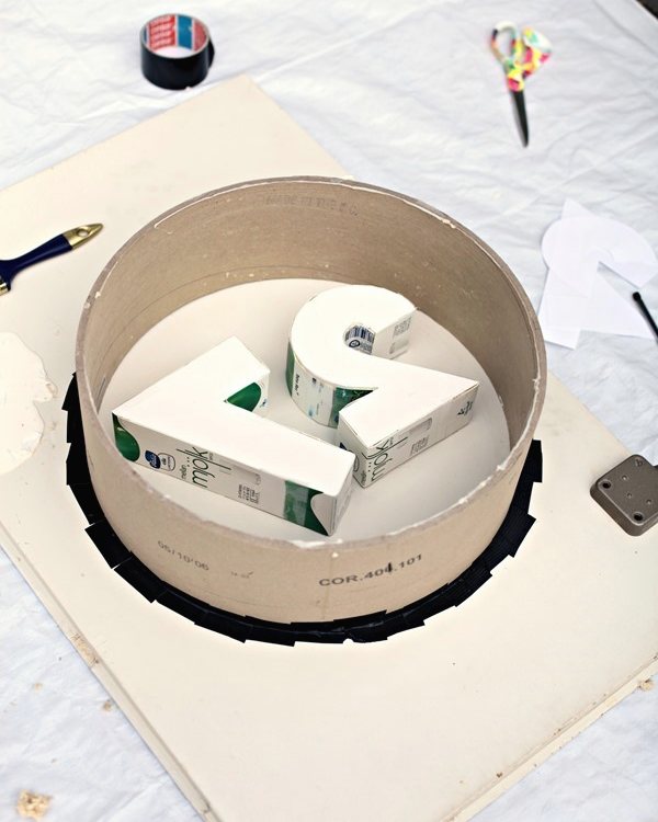 The cardboard tube mould taped to a board with the foam numbers glued inside