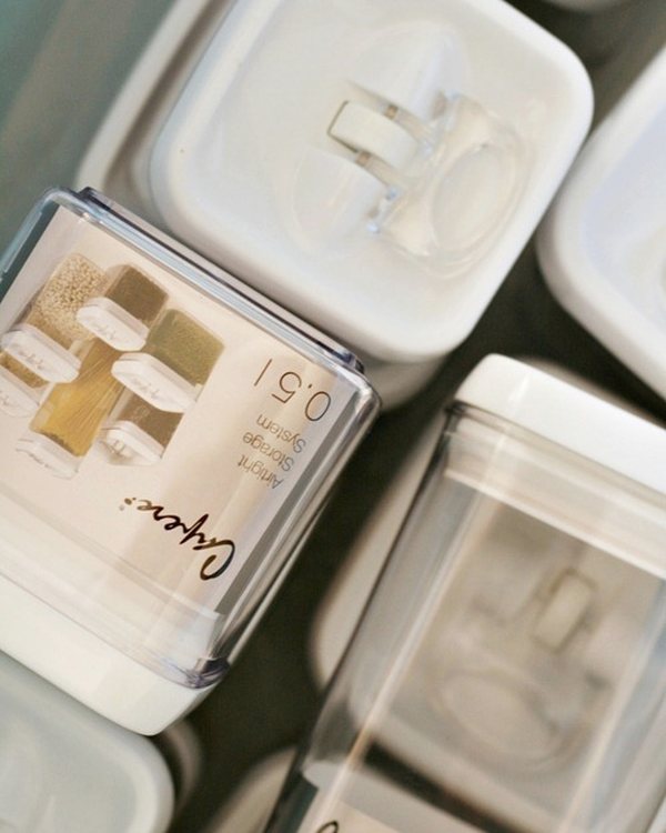 Two clear containers with white lids, labelled on the top