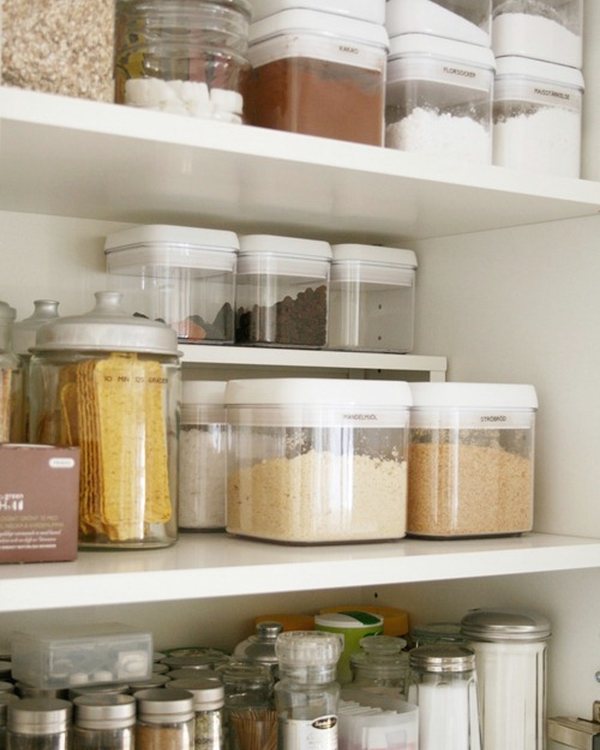 A pantry shelf of matched containers above rows of small spice jars