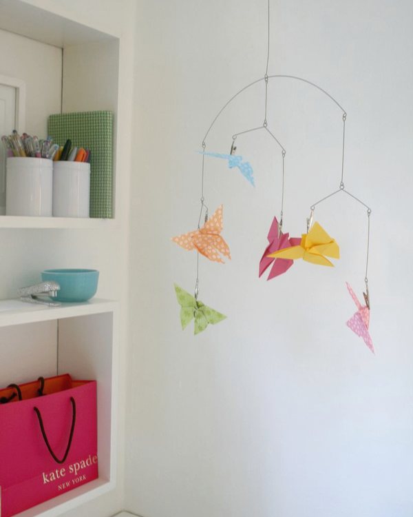 The butterfly mobile hanging over the desk in front of white shelving
