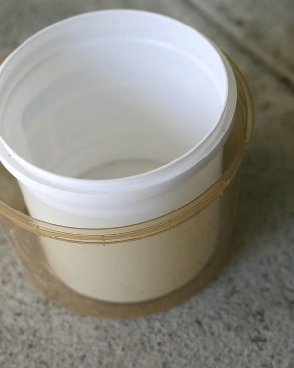 A plastic tub set inside a larger one, the gap between them filled with concrete