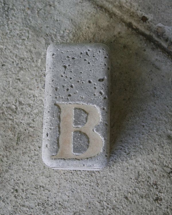 The bookend face up on a concrete floor, the letter B recessed into it