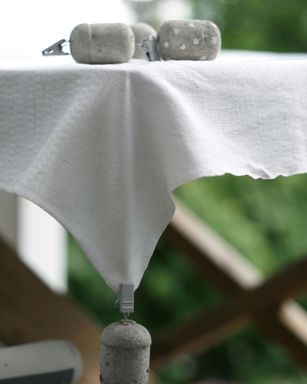 The finished concrete weights hanging from the corners of an outdoor tablecloth
