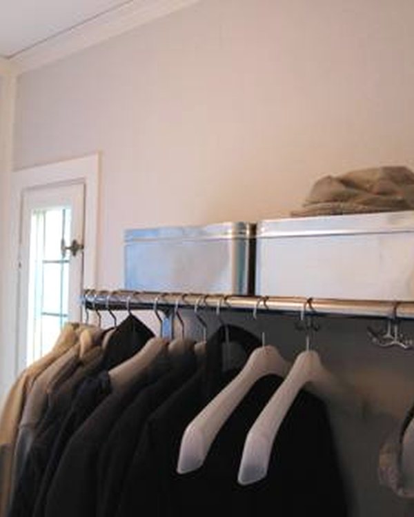 A hallway with a hanging rail and storage boxes above