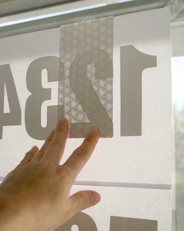 Tracing a number through the paper against the daylight from the window