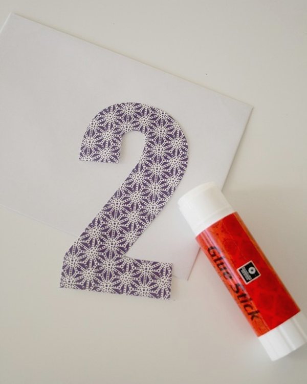 A cut-out number two beside a glue stick on a white envelope