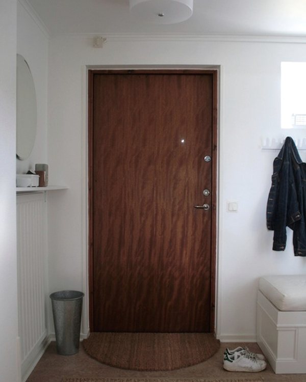 The curved coir mat inside the front door, hall floor and coats beyond