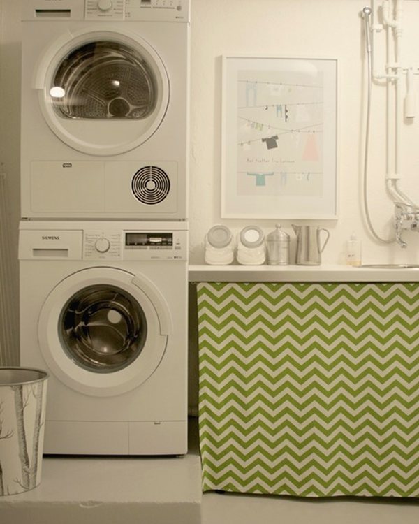 Stacked washer and dryer beside the worktop and framed print